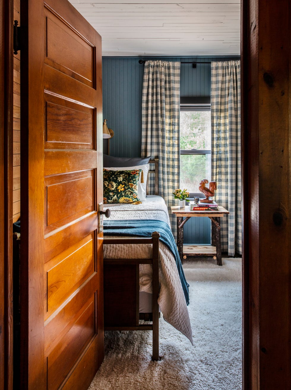 rustic farmhouse bedroom with blue beadboard walls and gingham curtains