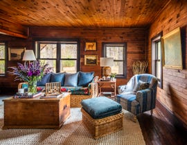 rustic farmhouse living room with wood walls and blue upholstery