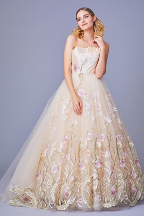 ミーチェのベージュゴールド系の刺しゅうが施されたカラードレスを着たモデルの写真。