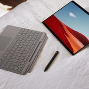 microsoft surface keyboard and pen on bed