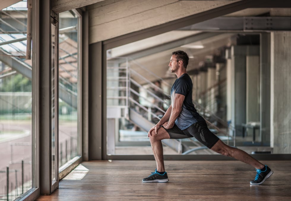 mid adult man doing lunges