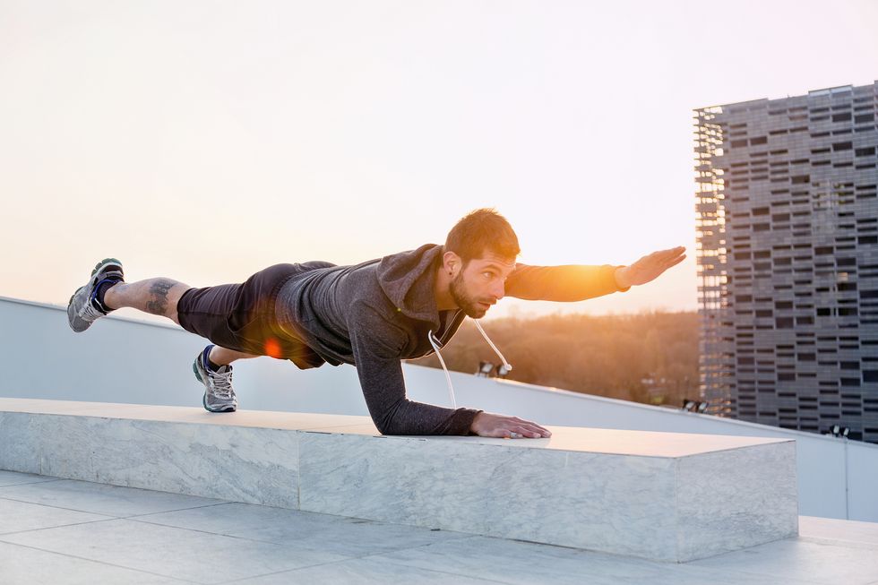 Mid adult man exercising outdoors, in yoga position
