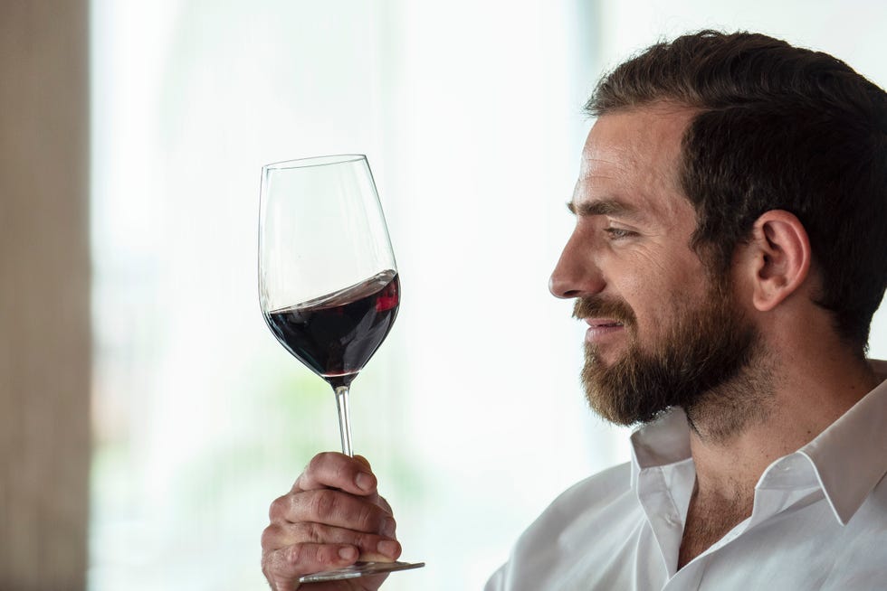 mid adult man holding red wine glass