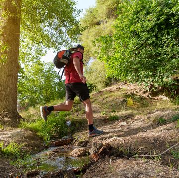 mid adult man practicing rucking in the mountain at sunset