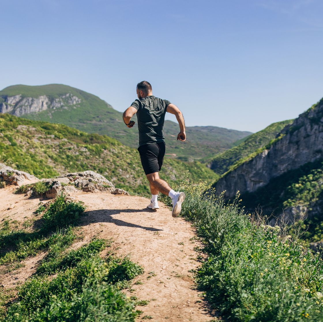 mid adult man running on the hill and mountain ridge