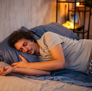 mid adult man sleeping in the bed at night