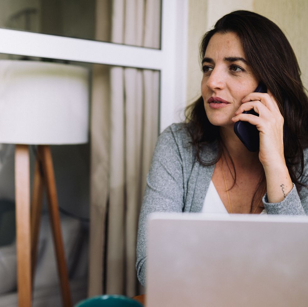 mid adult woman having a conversation over the phone on her balcony