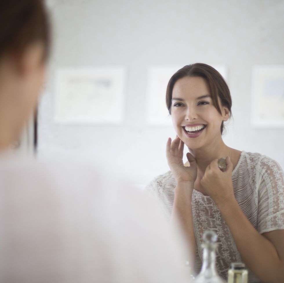 mid adult woman looking at herself in mirror