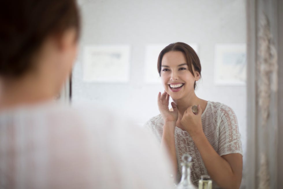 mid adult woman looking at herself in mirror