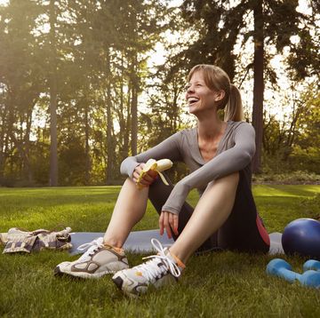 mid adult woman sitting in park taking exercise break