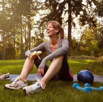 mid adult woman sitting in park taking exercise break