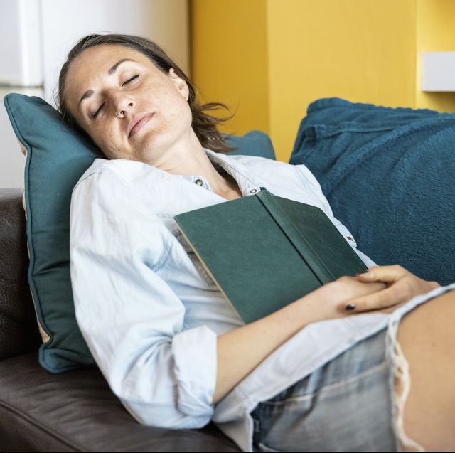 mid adult woman sleeping on sofa at home