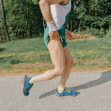 middle age man running on the side of a asphalted mountain road