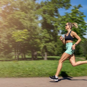 middle aged slim caucasian woman sportswear running,jogging running in park in sunny day summer,russia