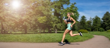 middle aged slim caucasian woman sportswear unit running,jogging training in park in sunny day summer,russia