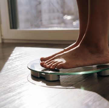 a middle aged woman standing in the morning on the scales
