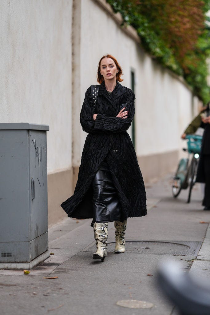 paris, france september 30 a guest wears black textured coat, shiny black leather midi skirt, white black snakeskin patternprint heeled slouchy leather boots, outside gabriela hearst, during the paris fashion week springsummer 2025 on september 30, 2024 in paris, france photo by edward berthelotgetty images