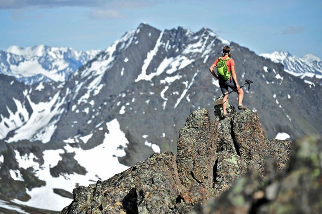 Wandelaars staan op de bergkam die de Flattop Mountain Peak 2 Peak 3 en de Flaketop verbinden met de Ptarmigan Pass in het Chugach State Park bij Anchorage De zesenhalve kilometer lange oversteek is populair bij de plaatselijke bevolking en geschikt voor traillopers