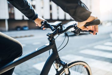 a midsection of businessman commuter with electric bicycle traveling to work in city