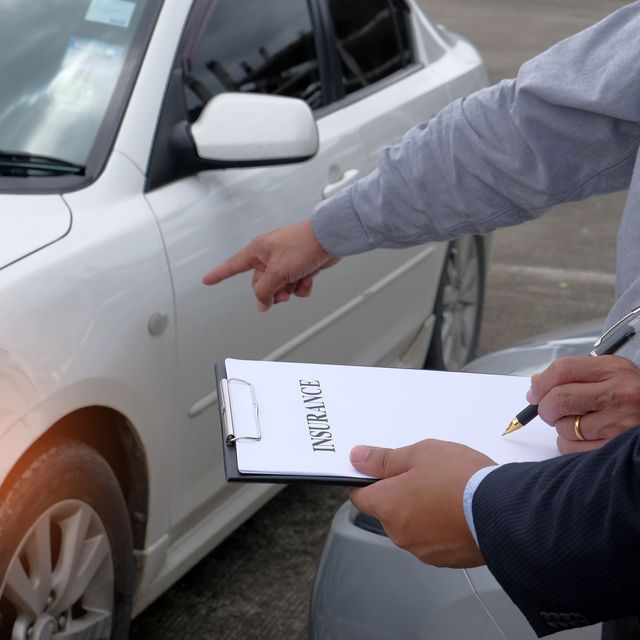 Midsection Of Client And Insurance Agent Standing With Document By Car