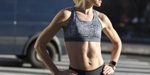 midsection of female athlete standing on street during sunny day