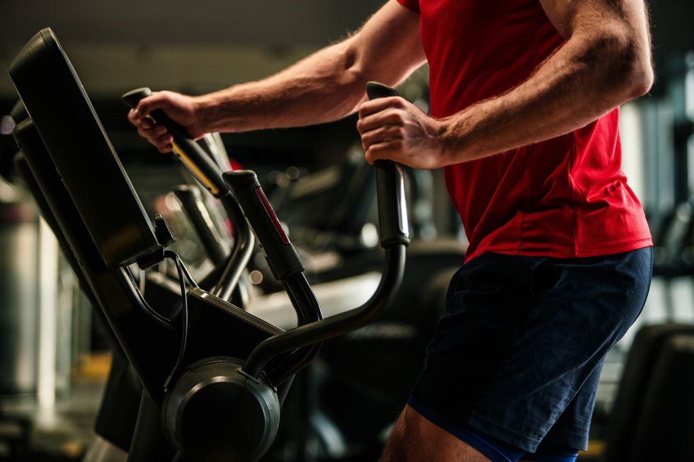midsection of male athlete doing cardio on elliptical machine