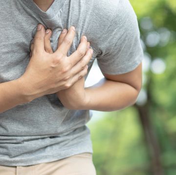 midsection of man having chest pain against trees