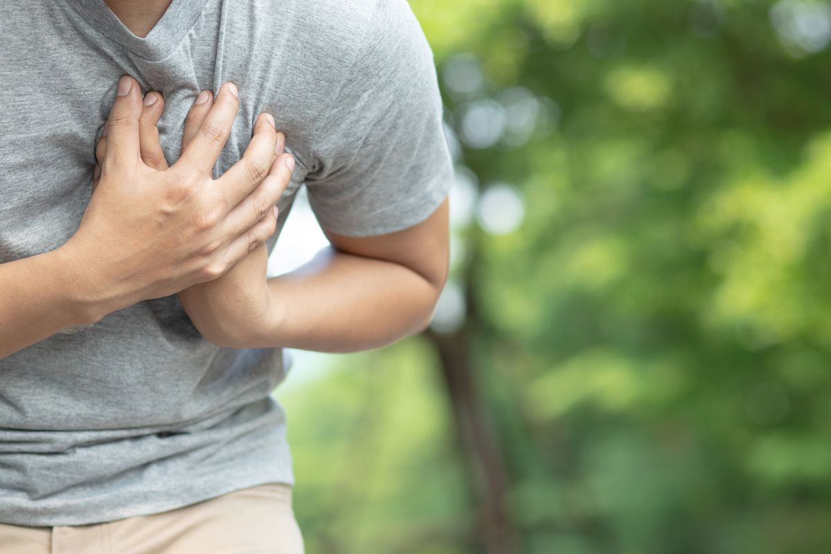 midsection of man having chest pain against trees