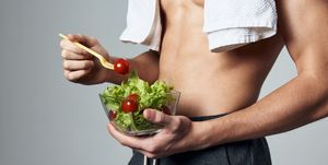 midsection of man holding salad against gray background