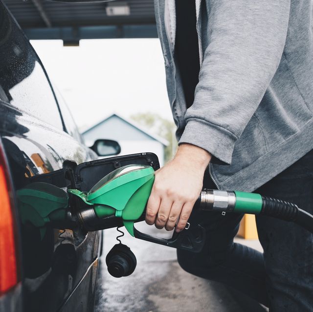 midsection of man refueling car at gas station