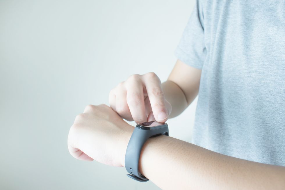 midsection of man wearing smart watch against white background
