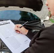 midsection of man writing on car insurance paper