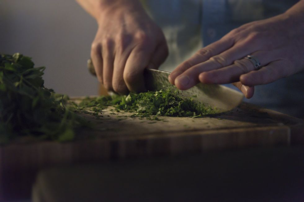 midsection of person preparing food on cutting board