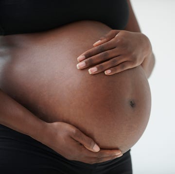 midsection of pregnant black woman holding belly