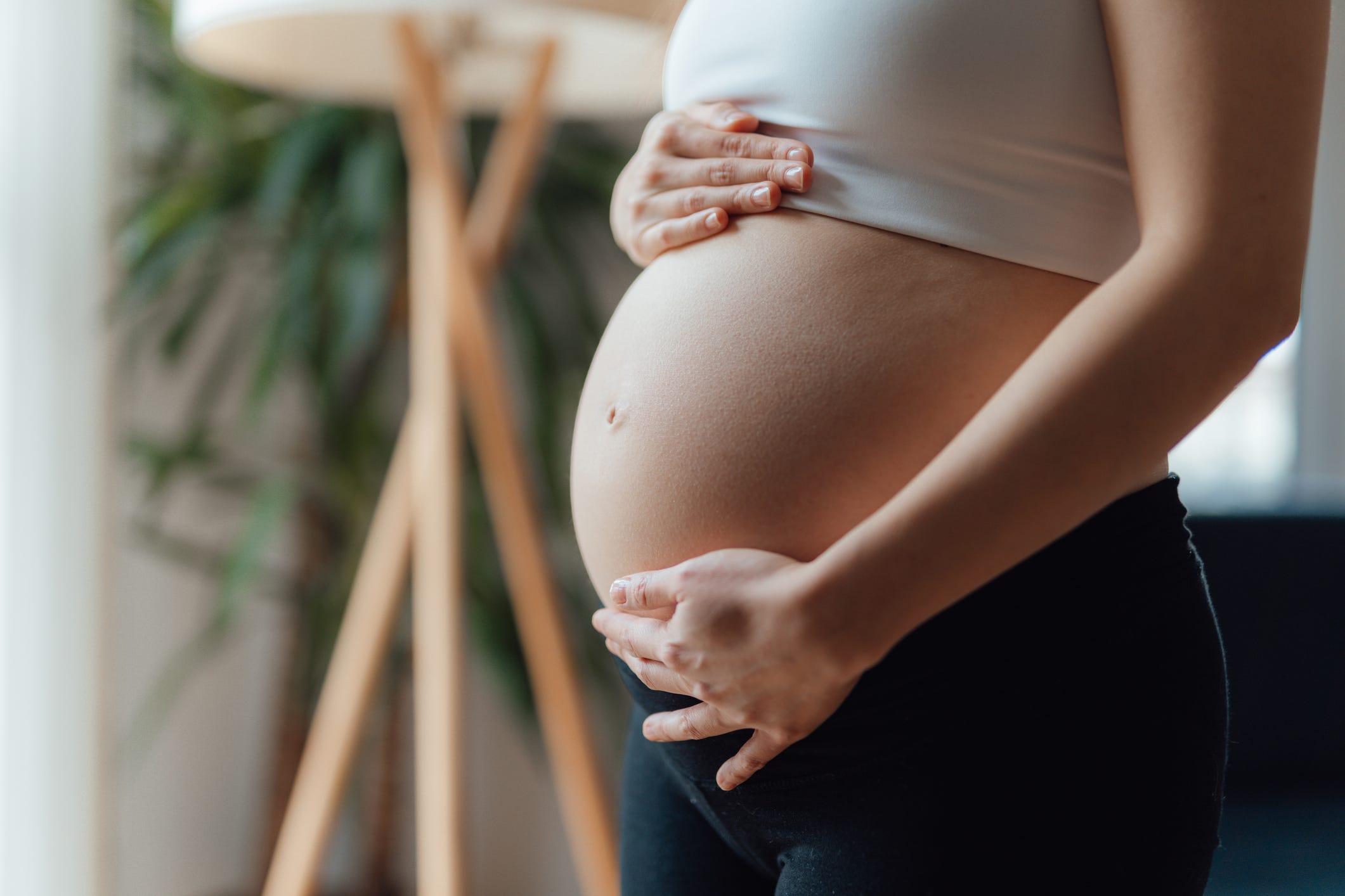 midsection of pregnant woman holding her belly