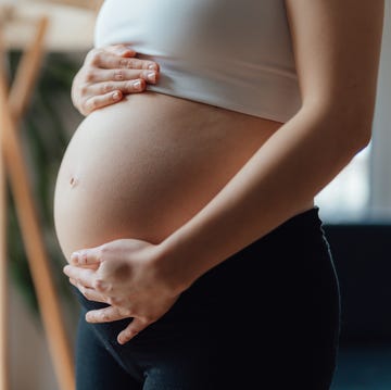 Midsection of Pregnant Woman Holding Her Belly midsection of pregnant woman holding her belly
