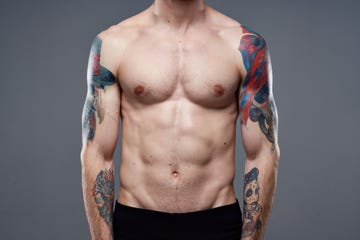 midsection of shirtless man standing against black background