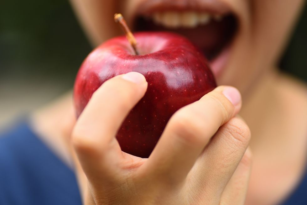 Midsection Of Woman Eating Apple
