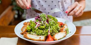 Midsection Of Woman Eating Salad In Bowl