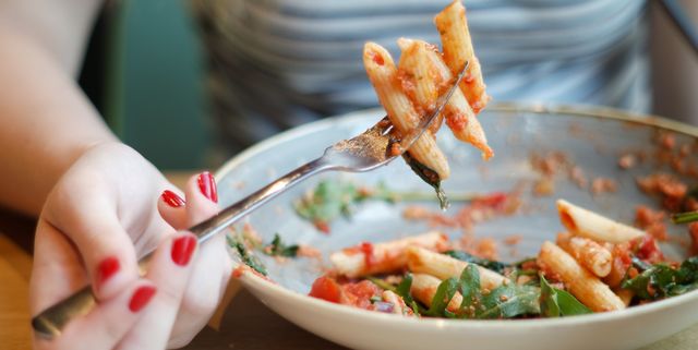 Midsection Of Woman Having Pasta At Table
