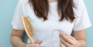 postmenopausal hair loss in women over 50 new study midsection of woman holding brush with hair against blue background