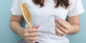 postmenopausal hair loss in women over 50 new study midsection of woman holding brush with hair against blue background