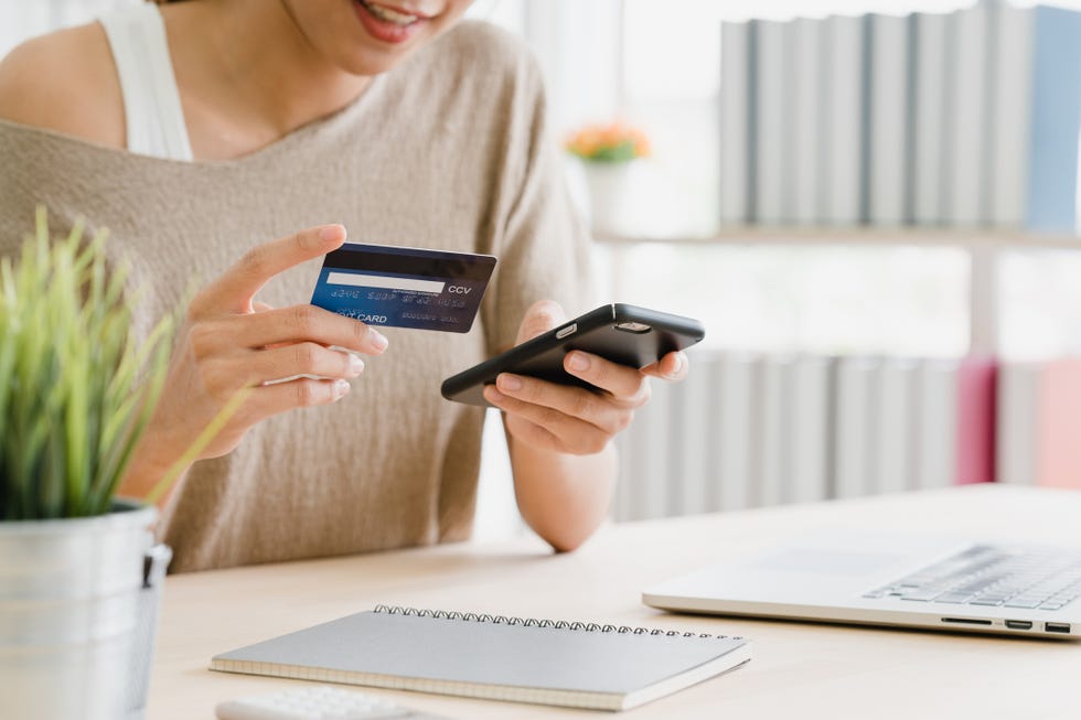una mujer paga con tarjeta una compra online