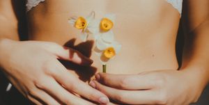 midsection of woman holding flowers outdoors