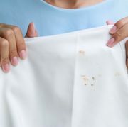 midsection of woman holding stained clothing at home
