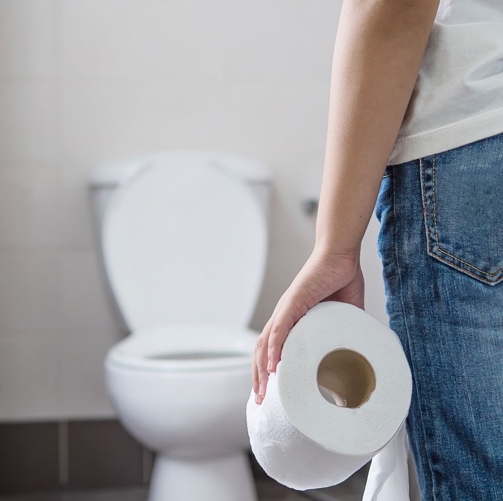 Midsection Of Woman Holding Toilet Paper While Standing In Bathroom
