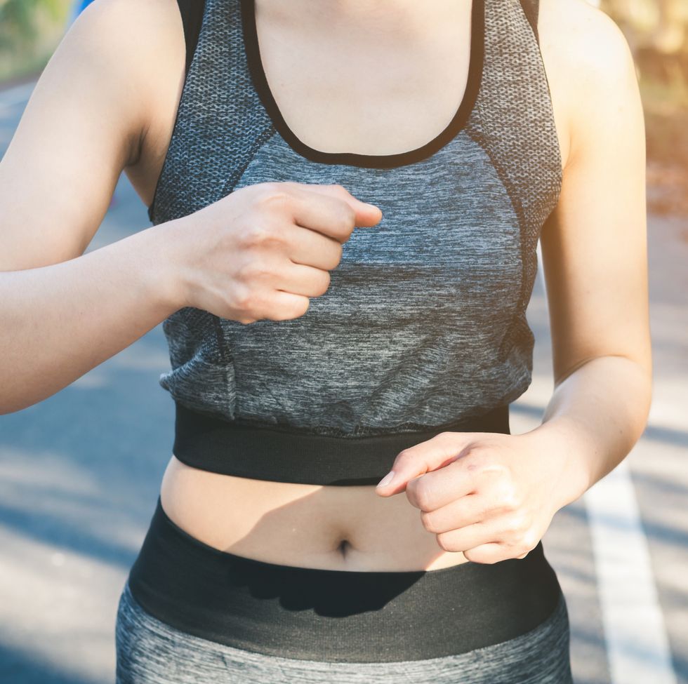 Midsection Of Woman Jogging On Road