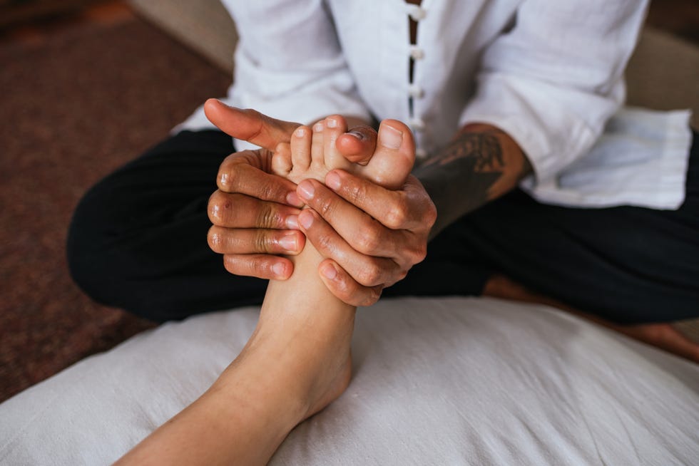 midsection of woman massaging customer while sitting on floor