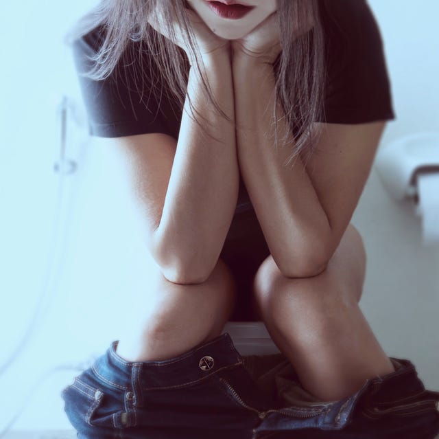 midsection of woman sitting on toilet seat