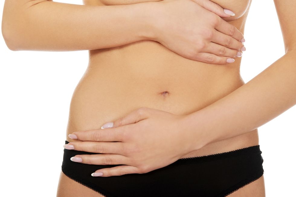 midsection of woman touching abdomen